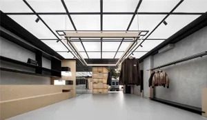 現代服裝零售店展示極簡設計，搭配混凝土牆面與金屬點綴