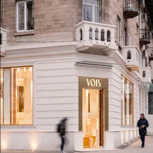Modern retail storefront with large glass windows and illuminated signage.
