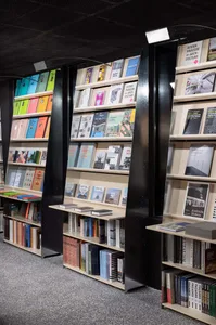 A modern bookstore with tall, sleek shelves displaying colorful books and architectural books.