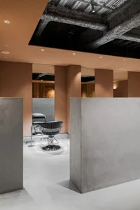 Industrial-style hair-saloon interior with concrete walls and ceiling
