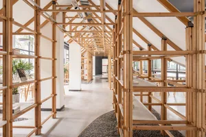 A spacious library interior featuring wooden shelves and a ceiling with exposed beams.