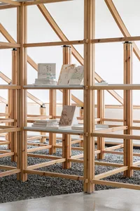 A minimalist wooden library with open shelving and books.
