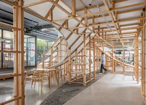 An interior view of a modern cafe with wooden structures and tables.