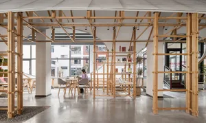 A modern cafe interior with wooden architectural frameworks and large windows allowing natural light.