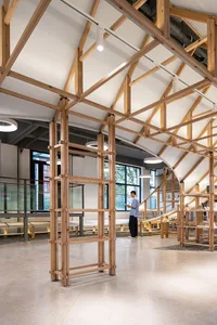 A spacious library with a modern design, featuring a ground floor with a wooden frame structure and large windows allowing na