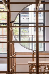 A modern restaurant interior with wooden frames and a view through the windows.