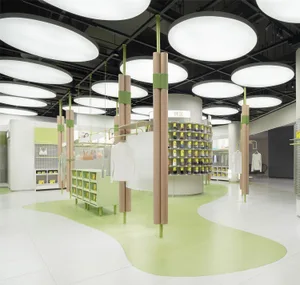 A modern retail space featuring wooden columns, green walls, and concrete flooring.