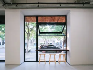 Modern cafe interior with wooden accents and stools.