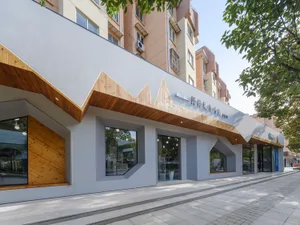 Modern exterior view of a cultural center with wooden accents and concrete columns.