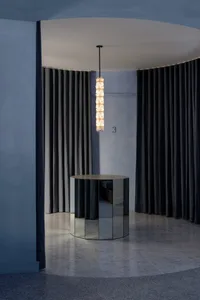 A minimalist lobby featuring a black mirrored panel with modern design elements.