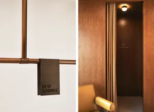 現代零售室內設計，展示一間擁有木質牆面與皮革家具的試衣間。