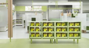Modern retail store with metal shelves displaying green boxes.