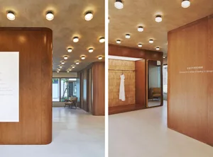 Modern retail storefront featuring wooden paneling and elegant lighting.