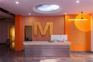 Minimalist reception desk with a concrete countertop and a large orange wall feature.