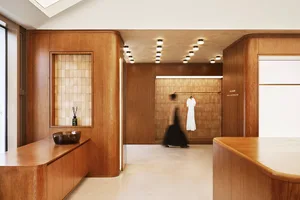 A modern minimalist shopping center with wooden cabinets, glass panels, and concrete flooring.