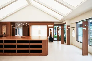 A modern retail store with a wooden counter displaying clothing.