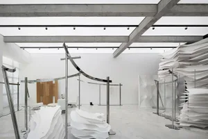 Minimalist exhibition space featuring paper and metal installations.
