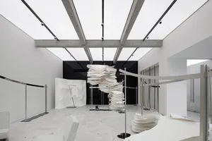 A minimalist showroom displaying clothing on modular paper structures