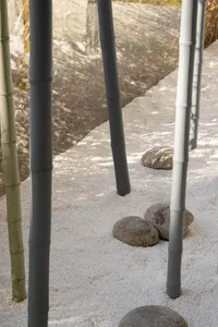 A minimalist bamboo walkway lined with white pebbles, creating a serene and tranquil outdoor space.
