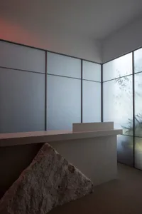 簡約俐落的現代工業風大廳，搭配混凝土牆面與大型岩石造景