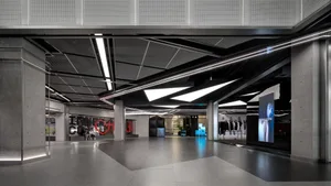 Industrial-style shopping center interior with concrete floors and minimalist design.