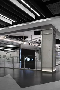 A minimalist retail storefront featuring metal, glass, and concrete materials.