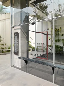 A modern glass storefront with a sign that reads 'in the PARK'.