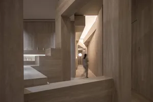 Modern hotel lobby with stone walls and floor, featuring minimalist design elements.