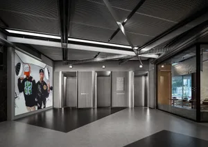 Modern industrial-style lobby with concrete, metal, and glass elements.