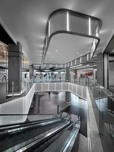 A modern mall interior featuring glass, concrete, and metal elements.