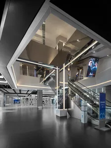 A modern shopping center interior with glass walls and steel railings.