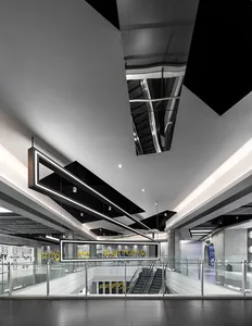 Modern shopping center interior with metal, glass, and concrete materials.