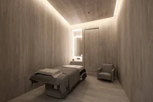 Modern spa treatment room with granite walls and floor.