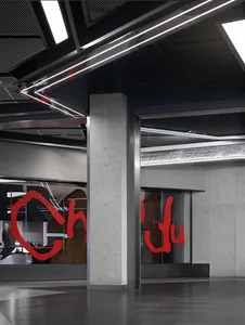 Industrial storefront with concrete walls and a large window display.