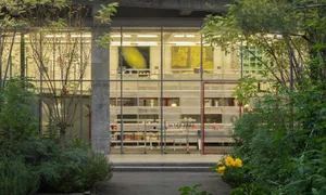 Modern minimalist exhibition space with glass walls displaying artwork.