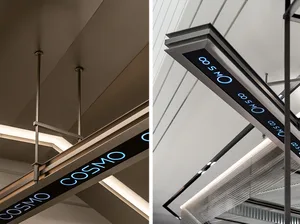 Industrial-style metal signage reading 'COSMO' mounted on a ceiling.