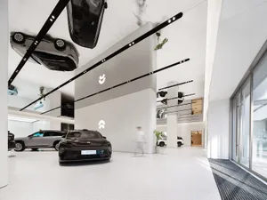 Minimalist car dealership interior with white cars and clean lines.