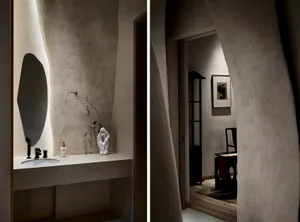 A modern bathroom with a concrete sink and mirror, featuring minimalist design elements and a sleek, contemporary aesthetic.
