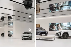 A modern car dealership showroom featuring sleek, minimalist designs with white floors and white accents.