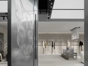 Modern clothing store entrance with metal panel featuring abstract design