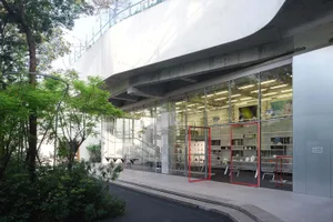 A modern storefront with glass walls and a concrete overhang.