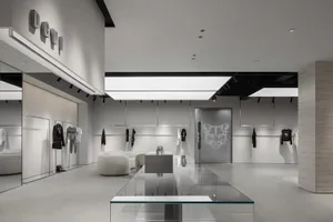Modern minimalist retail storefront with white walls, floors, and furniture, featuring neutral tones and sleek design element