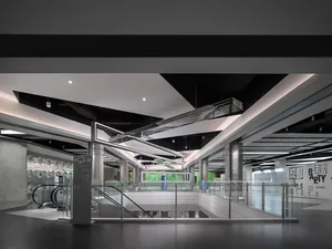 Shopping center interior featuring modern design with glass, metal, and concrete materials.