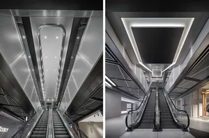 Modern interior design of a shopping mall showing metallic ceiling lighting and escalators.
