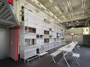 A spacious showroom featuring industrial-style furniture made of metal and glass.