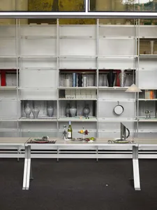A metal and glass display case holding various objects within an interior design setting.