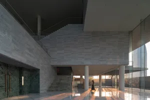 Modern corporate hallway with concrete walls and floors, featuring a sleek, minimalist design.