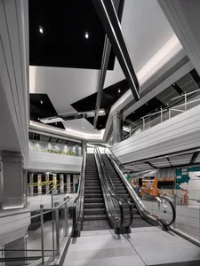 Modern interior design featuring a sleek, metallic escalator and contemporary architectural elements.
