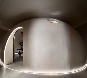 A modern living room with a concrete wall and floor, featuring minimalistic design elements.