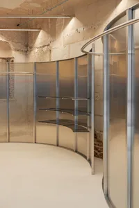 A modern, glass shelving unit with steel elements in retail space